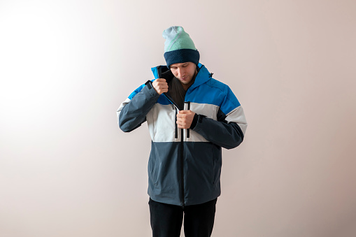 young man put on winter snowboard jacket, warm clothes dressing