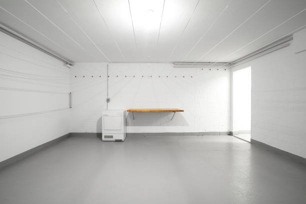 istock Apartment building common use empty laundry room. Empty wooden table top, dryer and hanging wires on the wall. Wide-angle view, no people 1768863035