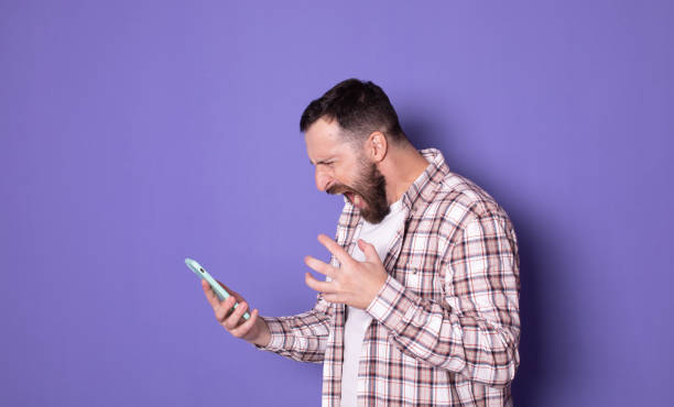 istock Angry screaming young handsome bearded man talking by mobile phone. 1768867606