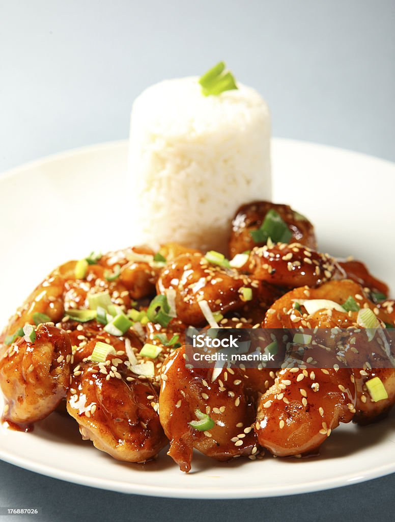 Sesame chicken with rice A close-up of a portion of sesame chicken with rice served on a white plate Chicken Meat Stock Photo