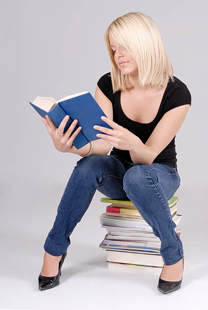 istock beautiful young blond student sitting on books 176887187