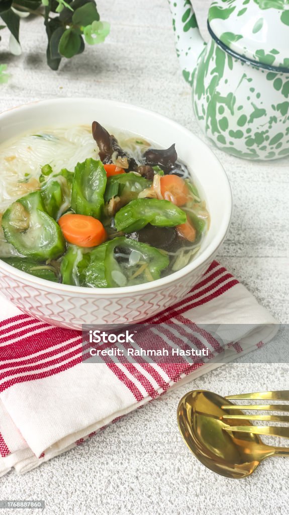 Clear soup of carrot, vermicelli and gambas or clear soup of carrot, vermicelli and luffa vegetables. Serve in white ceramics bowl. Selective focus Bowl Stock Photo