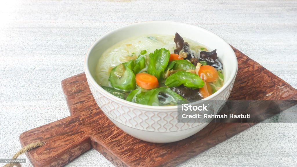 Clear soup of carrot, vermicelli and gambas or clear soup of carrot, vermicelli and luffa vegetables. Serve in white ceramics bowl. Selective focus Bowl Stock Photo