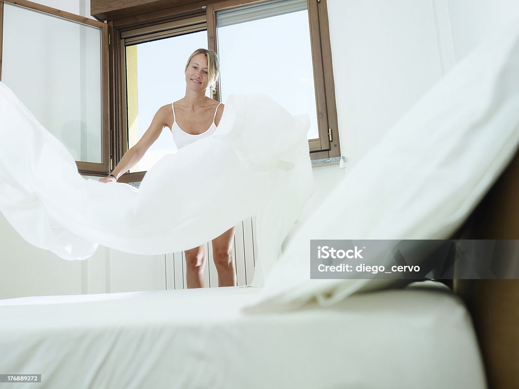 Mujer haciendo tareas domésticas - Foto de stock de Sábana - Ropa de cama libre de derechos