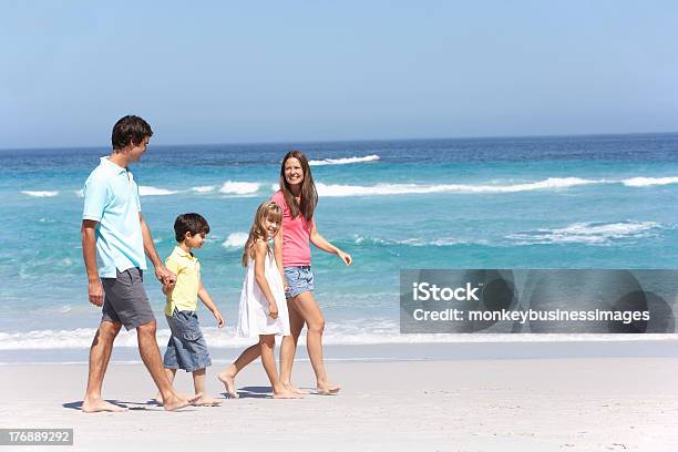 Family Walking Along Sandy Beach Stock Photo - Download Image Now - 30-39 Years, 4-5 Years, 6-7 Years