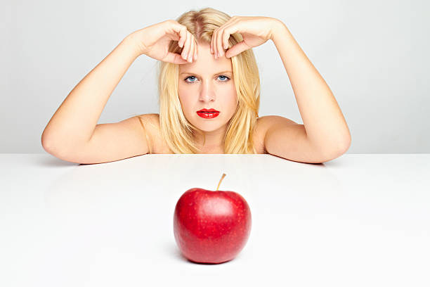 young blond woman with red apple stock photo