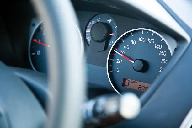 The dashboard of car going 40, within speed limits. Very shallow depth of field.
