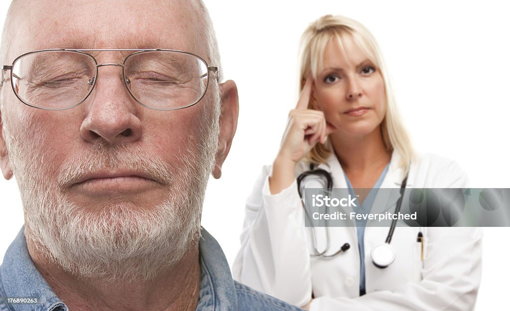 Preocupado Senior hombre y mujer médico detrás - Foto de stock de 70-79 años libre de derechos