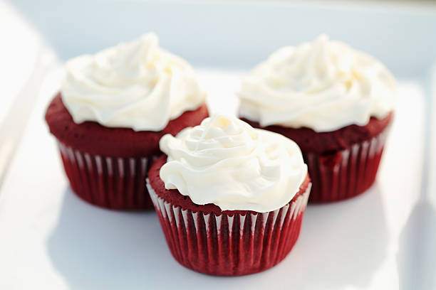 Three red velvet cupcakes on a white plate stock photo