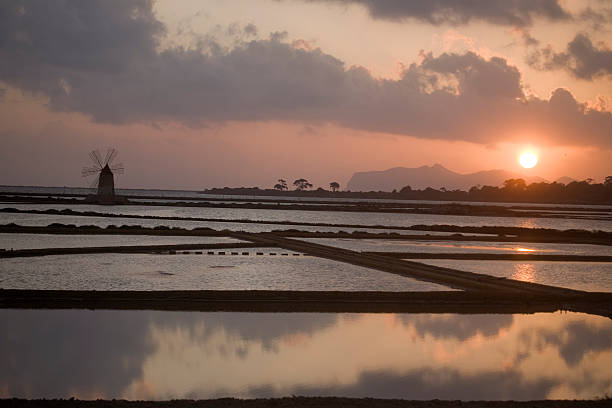 istock Salt farm with windmill at sunset 176890991