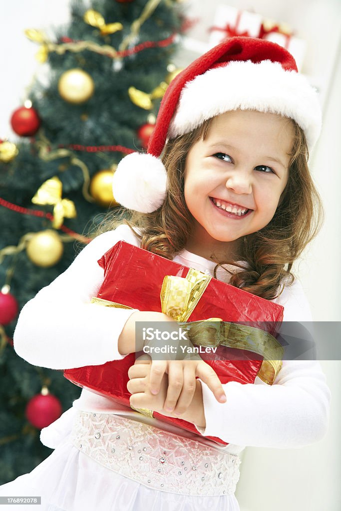 Christmas girl Portrait of little cute girl with Christmas present Beautiful People Stock Photo