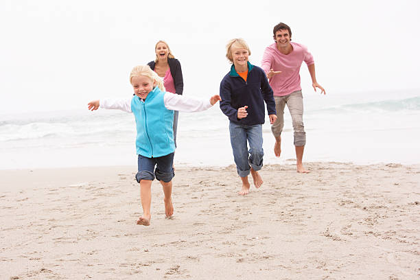 istock Young Family Running Along Winter Beach 176892808