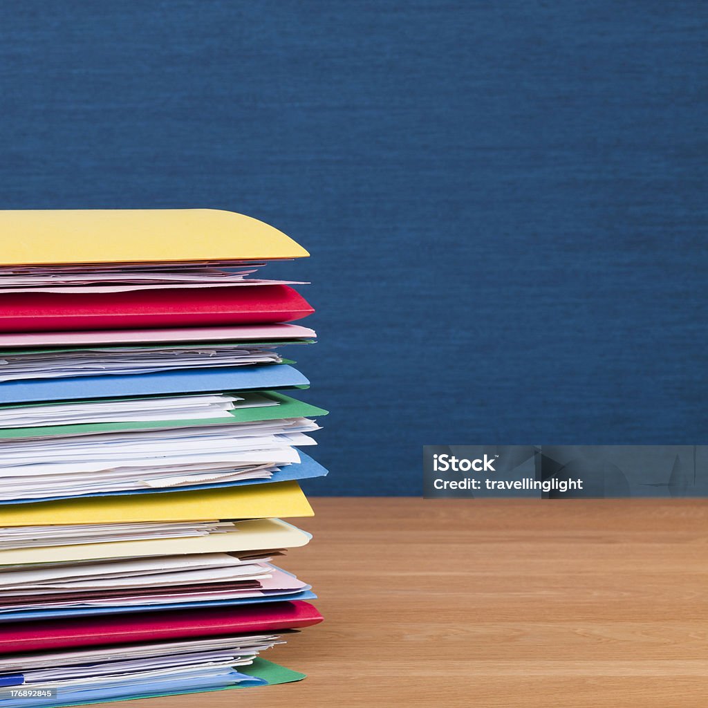 Pila de coloridas carpetas de archivos en escritorio de madera - Foto de stock de Archivo libre de derechos