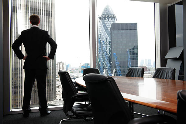 istock A businessman standing in the board room looking outside 176894292