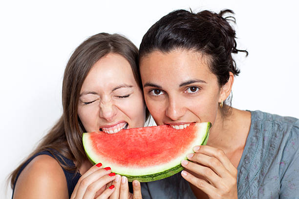 istock Two women take a bite of watermelon 176894819