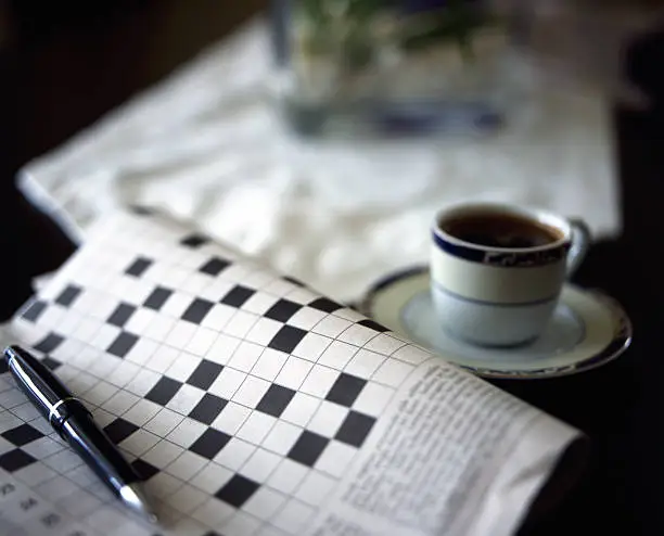 blankcrossword puzzle with a pen and black coffee