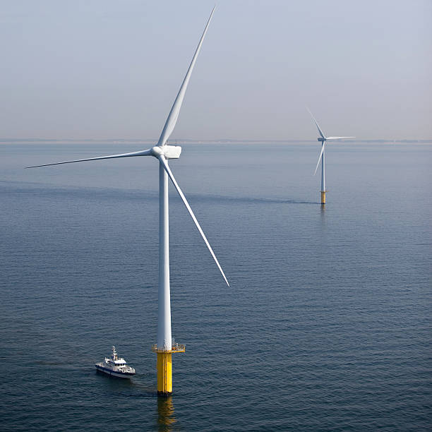 Wind turbine at sea during maintenance stock photo