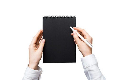 Woman hand with pencil writing on notebook. Woman working on office table. Female hand holding pencil and sketchbook. Mock-up Concept.