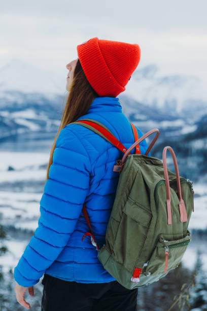 istock Woman With Backpack Looking at Dramatic Winter Mountain Landscape from Above Contemplating Snow 1768969328