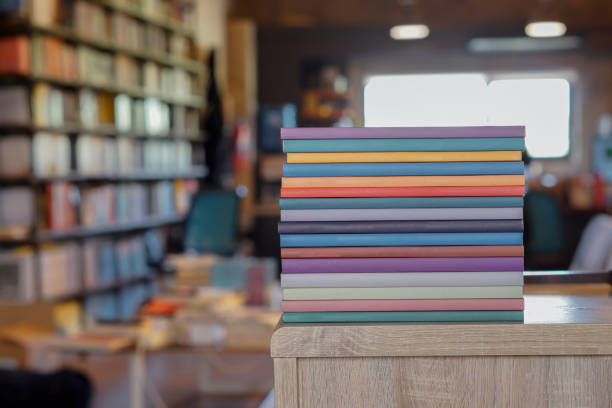 Stack of colorful books on wooden desk in the library room background. Education and knowledge concept. Pile of books to read. stock photo