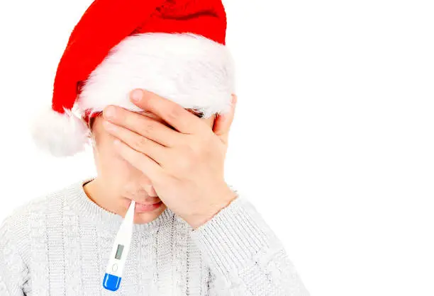 Sick and Unhappy Man in Santa Hat with a Thermometer close his Eyes Isolated on the White Background