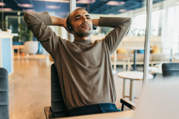 istock Businessman with hands behind head, contemplating on work in call center office 1768976068
