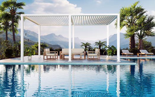 3D illustration of a 6 post white bioclimatic pergola on sundeck next to pool. Lush green garden with palm trees and mountain view.
