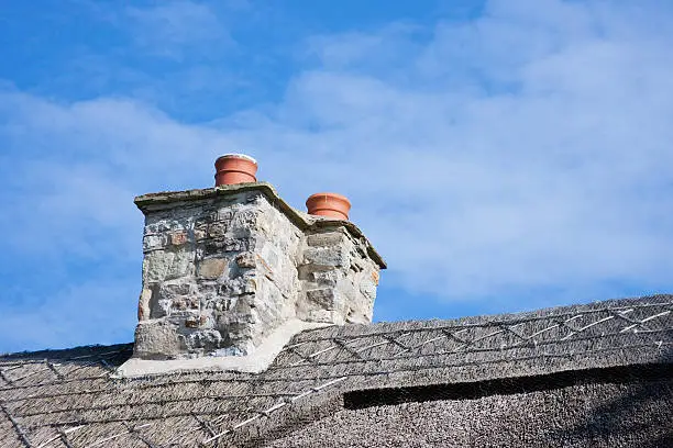 Thatched Roof Chimneys against Blue Sky with Traditional Decorative Thatching
