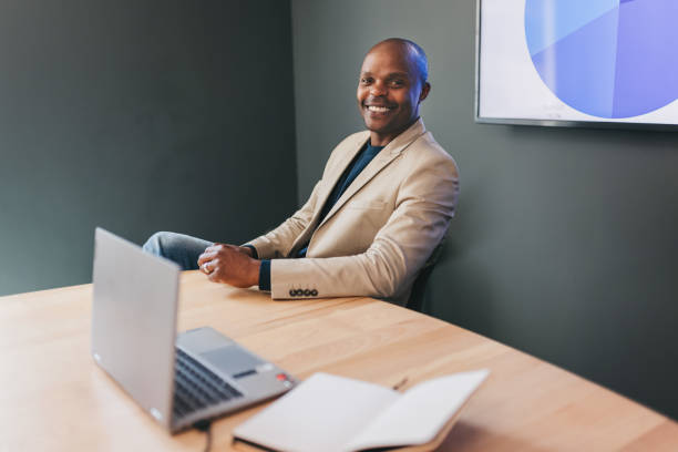 istock Businessman smiling cheerfully at camera at meeting table in boardroom 1768990625