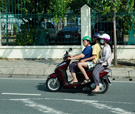 Saigon, Vietnam-September 8, 2018:Three people riding a scooter on a Ho Chi Minh City (Saigon), Vietnam street.