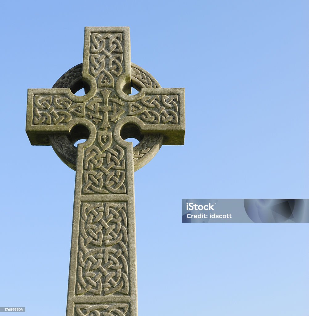 Carved stone celtic cross in a Scottish cemetry A celtic cross photographed against a blue sky.Old Headstones Blue Stock Photo