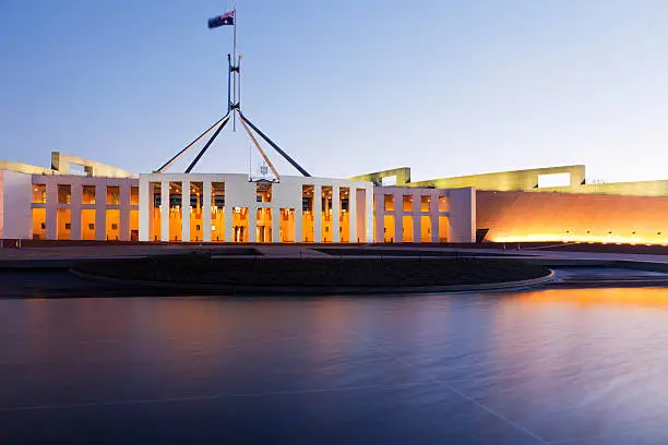 "Parliament House, Canberra, Australia, illuminated at twilight. Reflections in pool, Australian flag is flying.  For MANY MORE Australian images, please click"