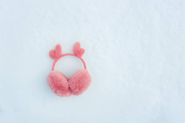 fur pink winter earmuffs on snow background