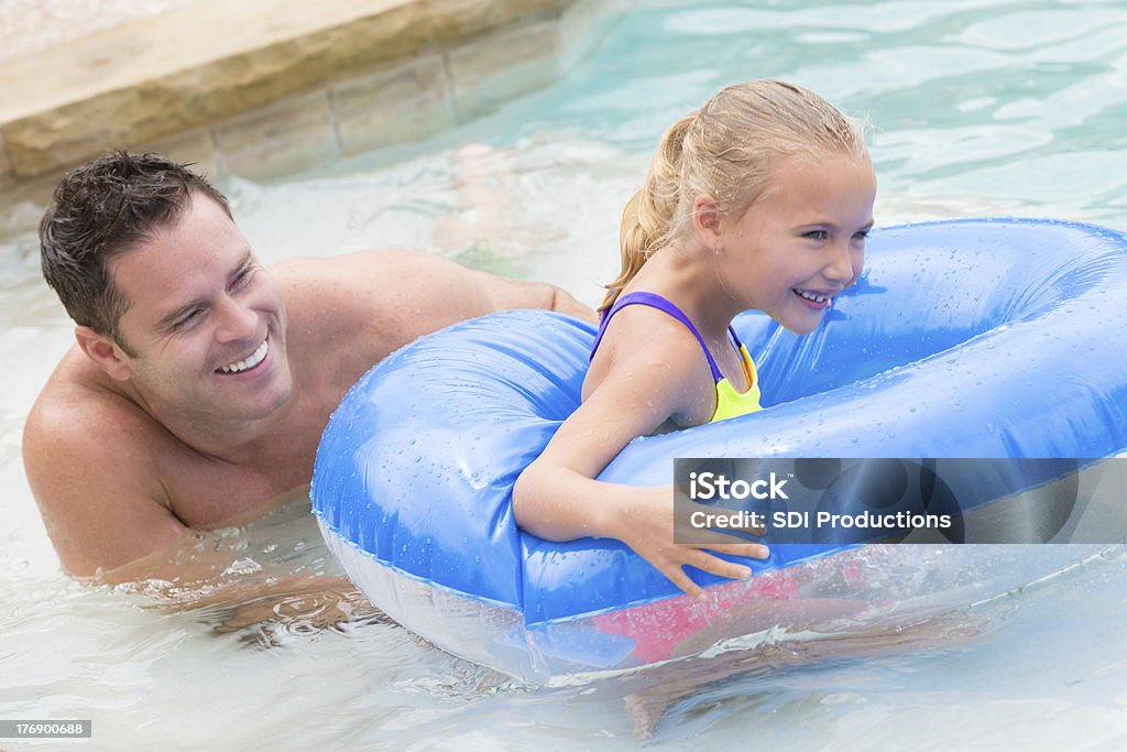 Père joue avec sa fille dans la piscine de flotter et piscine - Photo de Eau libre de droits