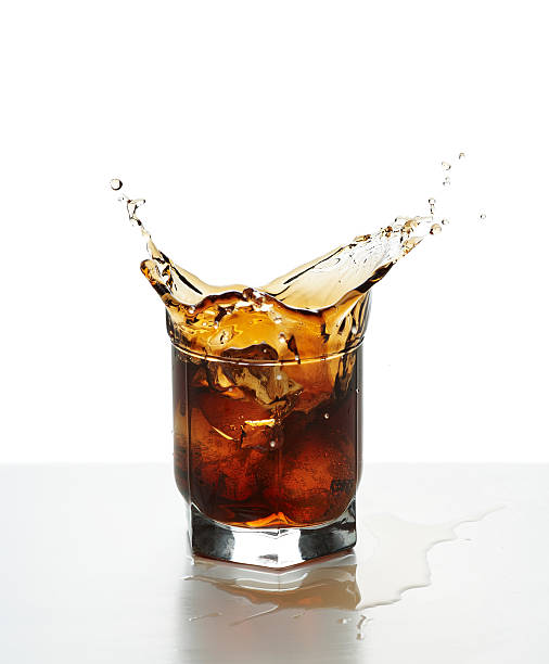 Glass with splashing whisky stock photo