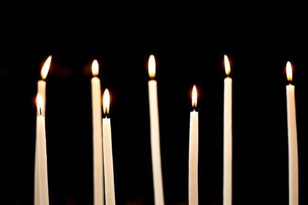 Group of Lit Church Candles on Black Background. Shot in Paris.
