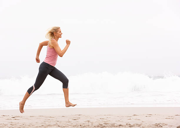 istock Young Woman Running Along Winter Beach 176902316
