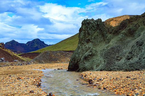 Amazing Iceland - dream for photographers and tourists. Landmannalaugar. Picturesque huge stone covered with green moss. Rhyolite mountains and streams.