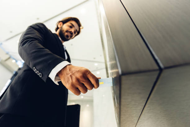 istock Businessman using card to open automatic gate machine in office building. Male using smart card to open automatic gate machine in office building. Working routine concept. 1769029143