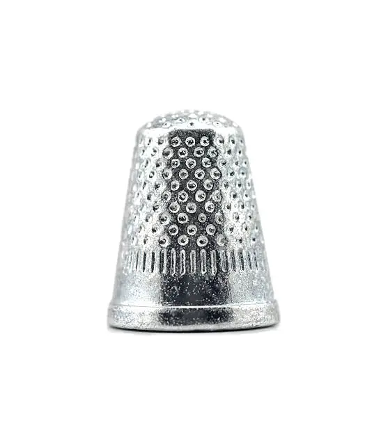 Studio shot of thimble isolated on white.Table game silver metal figure.