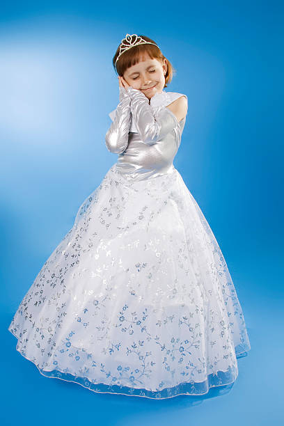 Child dressed up for first communion against blue sky