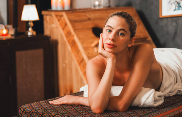 istock Pretty woman lies on spa bed during looking at camera at spa. Tranquility. 1769034273