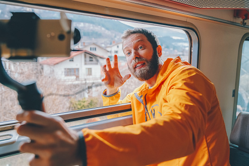 Man recording video for his blog while travelling in train