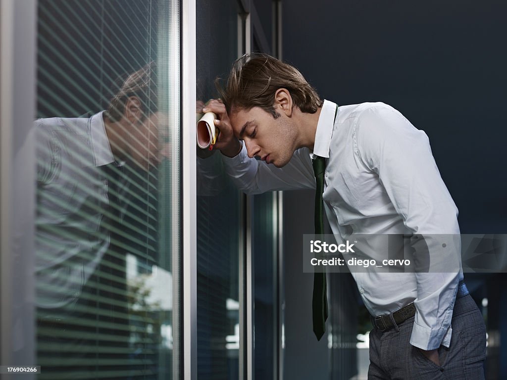 Triste Empresário inclinando a janela no escritório - Foto de stock de Homens royalty-free
