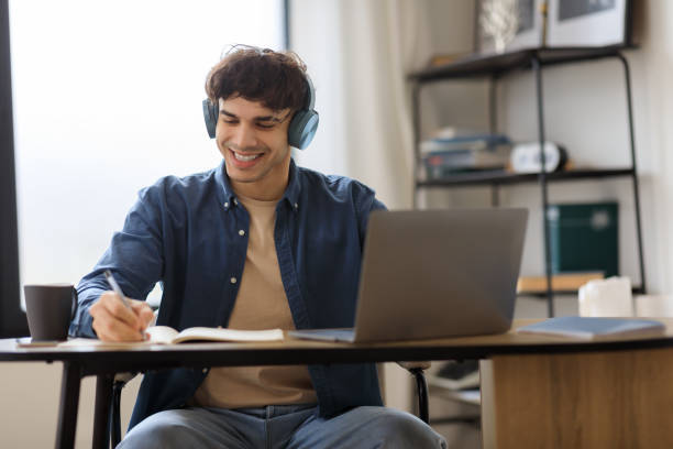 istock Middle Eastern Man At Laptop Taking Notes Wearing Earphones Indoor 1769051544