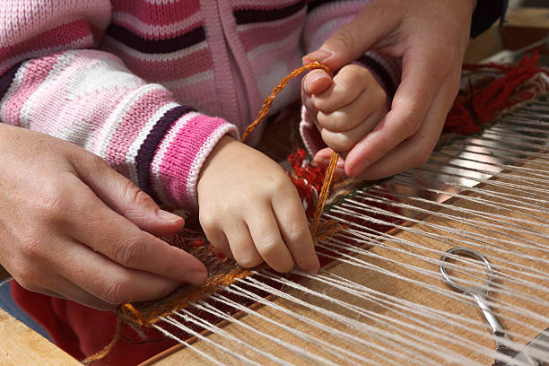 Two ladies weaving on handloom, Kullu Valley, Himachal Pradesh, India. Himachal Pradesh, a state in the Western Himalayas of northern India, characterised by extreme landscapes of mountain peaks and extensive river systems.