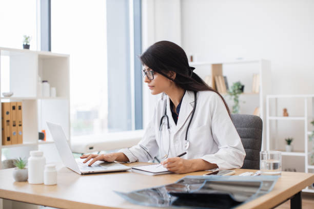 istock Doctor using computer while sitting at desk in health center 1769060447