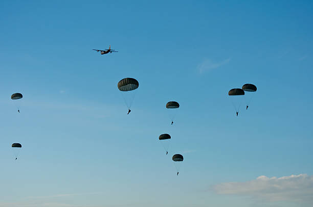 Military aircraft dropping paratroopers Military aircraft dropping paratroopers during an airshow: Operation Market Garden operation market garden stock pictures, royalty-free photos & images