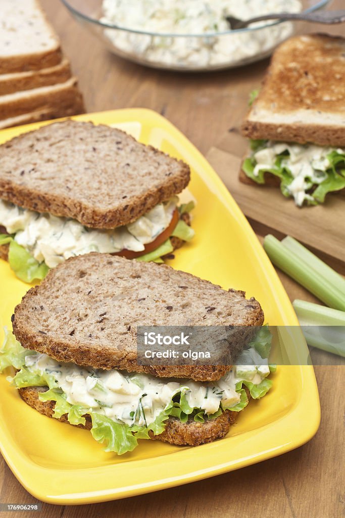 egg salad sandwiches egg salad sandwiches on whole wheat brown  bread and ingredients on wooden table Egg Salad Sandwich Stock Photo