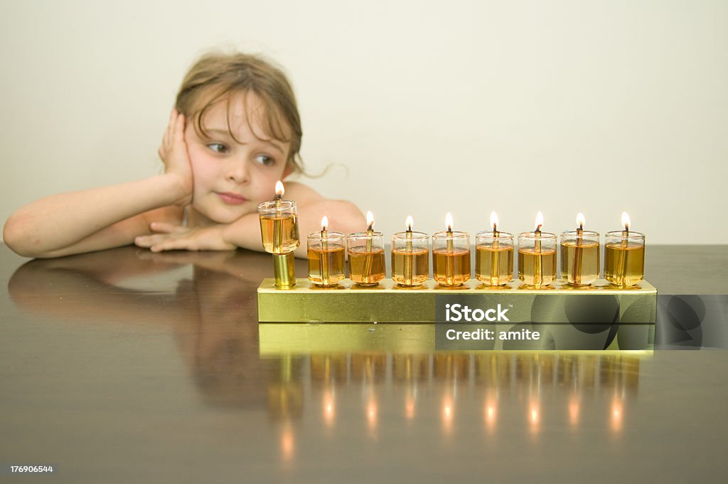 Ragazza sguardo all'Hanukkah menorah - Foto stock royalty-free di Attrezzatura per illuminazione